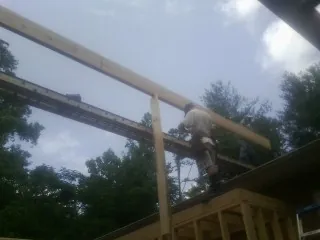 Carpenter setting a ridge beam over a new addition frame — Ice Dam Removal by Roofing Brothers in Markesan