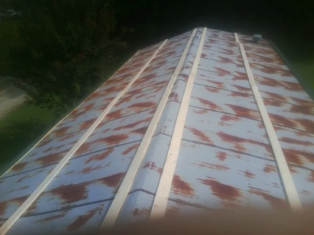 Rusted metal roof panels with new wood purlins before replacement — Storm Damage Roof Repair in Markesan by Roofing Brothers